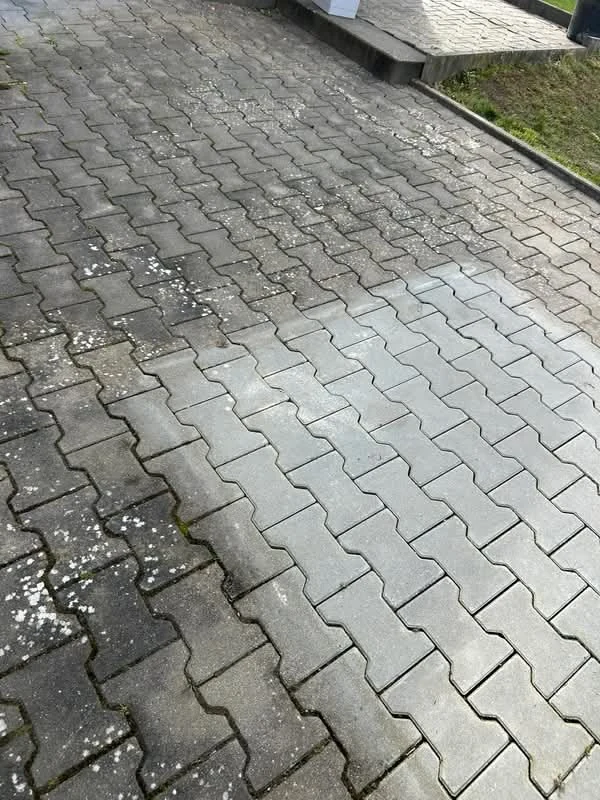 Voor-en-na reiniging van betonnen klinkers: links donker en bedekt met aanslag, rechts schoon en lichtgrijs